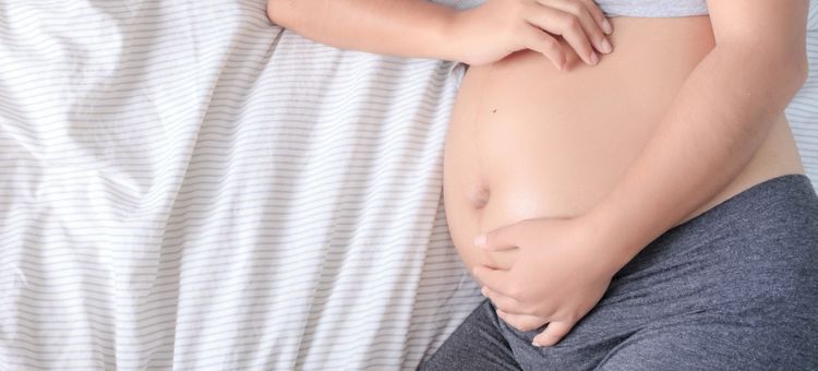 zbliżenie na brzuch leżącej kobiety w 20 tygodniu ciąży