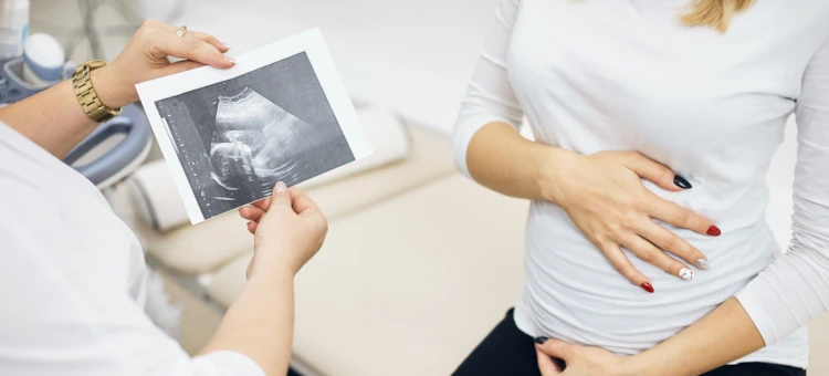 Lekarz prezentuje zdjęcie z ultrasonografii przyszłej matce