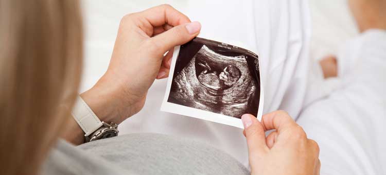 kobieta w ciąży ogląda zdjęcie USG