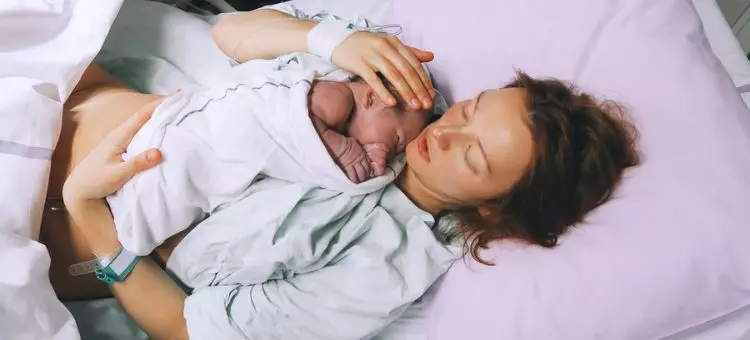 Matka trzymająca swoje nowo narodzone dziecko po porodzie w szpitalu