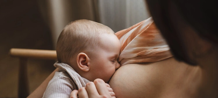 Nawał pokarmu – mama karmiąca niemowlę piersią