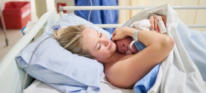 Mama leżąca na łóżku szpitalnym po porodzie