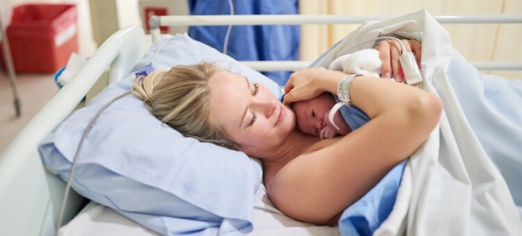 Mama leżąca na łóżku szpitalnym po porodzie