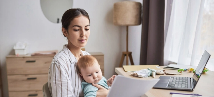 Mama z niemowlęciem przegląda dokumenty medyczne – książeczka zdrowia dziecka podczas wizyty lekarskiej