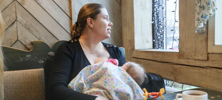 Mama karmiąca piersią noworodka w restauracji