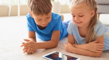 Rodzeństwo grające na tablecie w gry multimedialne
