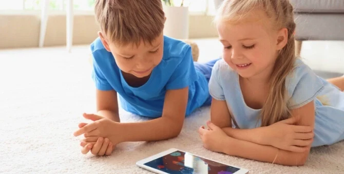 Rodzeństwo grające na tablecie w gry multimedialne