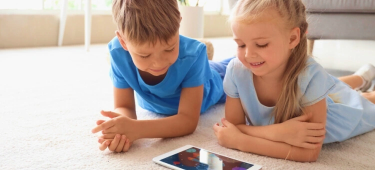 Rodzeństwo grające na tablecie w gry multimedialne