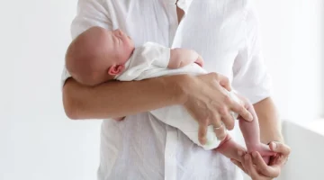 Prawidłowe noszenie noworodka na rękach z podparciem główki i pleców