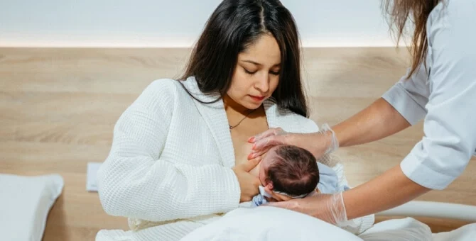 Położna środowiskowa na wizycie u młodej mamy