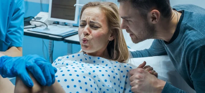 Kobieta wykonująca wydech podczas skurczu porodowego