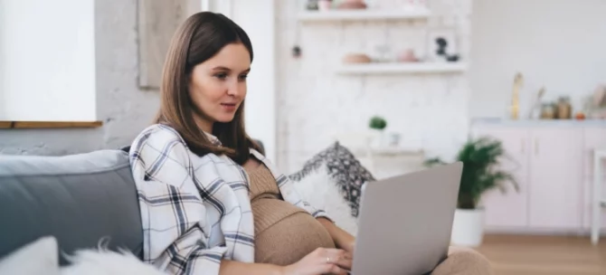 Mama przeglądająca szpitale do porodu na laptopie