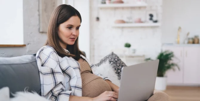 Mama przeglądająca szpitale do porodu na laptopie