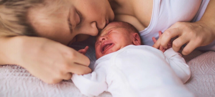 Mama leżąca z dzieckiem w czasie połogu po cc