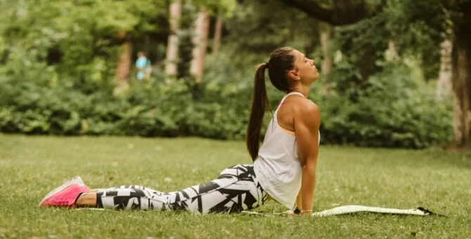 Kobieta ćwicząca jogę hormonalną na macie w parku