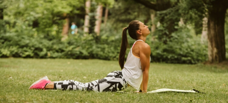 Kobieta ćwicząca jogę hormonalną na macie w parku