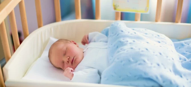 Noworodek śpiący na drzemce w łóżeczku