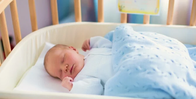 Noworodek śpiący na drzemce w łóżeczku