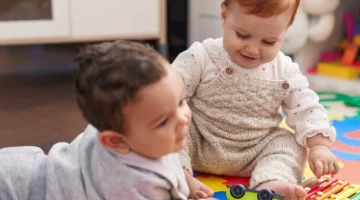 Niemowlęta w żłobku bawiące się na macie