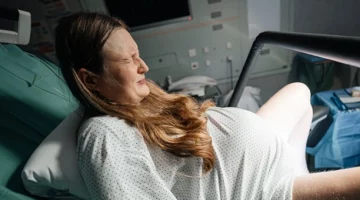Kobieta, która prze podczas porodu w pozycji półsiedzącej
