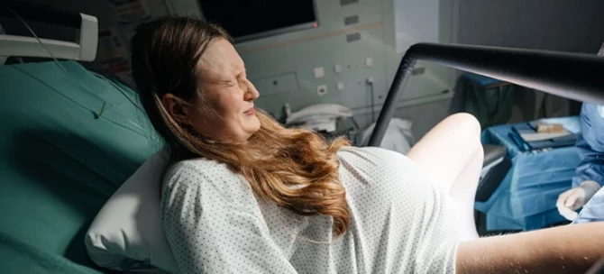 Kobieta, która prze podczas porodu w pozycji półsiedzącej