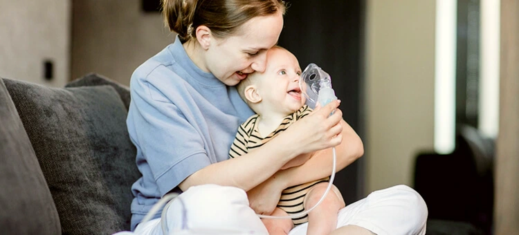 Po co nam nebulizator? Niemowlę podczas nebulizacji w obecności mamy