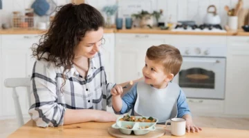 Mama jedząca śniadanie razem z rocznym synkiem