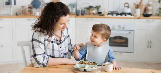 Mama jedząca śniadanie razem z rocznym synkiem