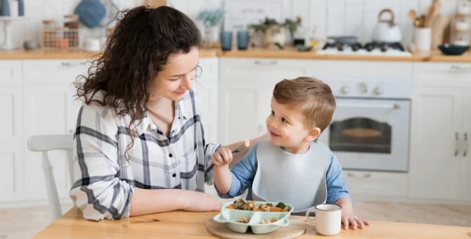 Mama jedząca śniadanie razem z rocznym synkiem