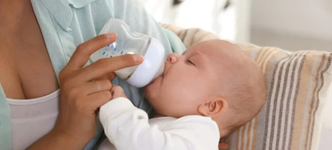 Niemowlę pijące mleko z butelki – wybór odpowiedniej butelki dla noworodka