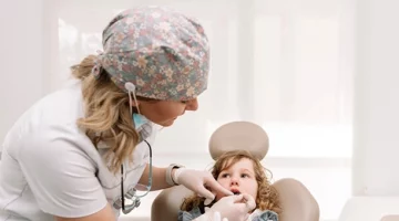 Mała dziewczynka podczas badania jamy ustnej u dentysty