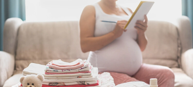 Mama składająca ubranka dla noworodka