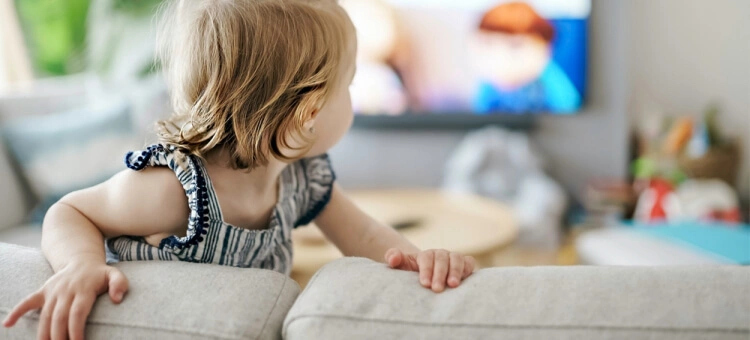 Dziecko oglądające telewizję na kanapie