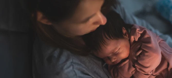 Mama usypiająca niemowlę do snu w nocy