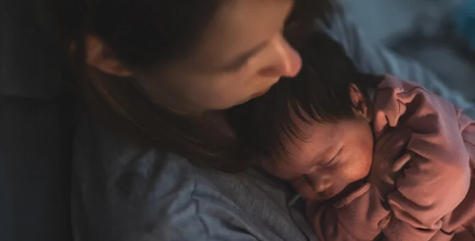 Mama usypiająca niemowlę do snu w nocy