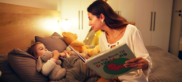 Mama czyta dziecku książkę przed snem, pomagając mu zasnąć we własnym łóżku