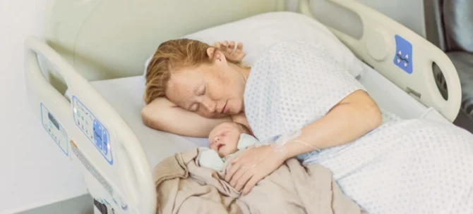Mama odpoczywająca z noworodkiem po porodzie w szpitalu – regeneracja organizmu w połogu