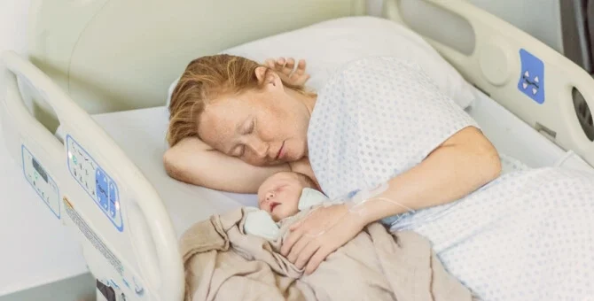 Mama odpoczywająca z noworodkiem po porodzie w szpitalu – regeneracja organizmu w połogu