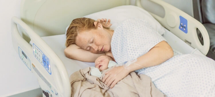 Mama odpoczywająca z noworodkiem po porodzie w szpitalu – regeneracja organizmu w połogu