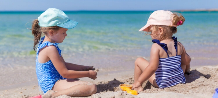 Siostry bawiące się w piasku na plaży