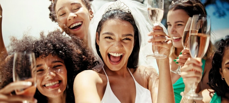 Dlaczego młodzi nie zapraszają dzieci na wesele? Panna młoda z przyjaciółkami wznosząca toast szampanem – wesele bez dzieci i swobodna zabawa dorosłych