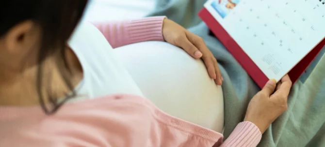 Mama spodziewająca się dziecka patrząca na kalendarz