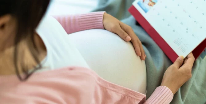 Mama spodziewająca się dziecka patrząca na kalendarz