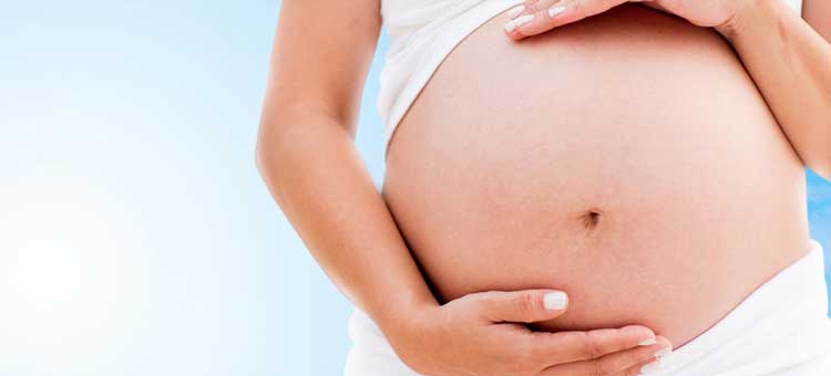 kobieta w drugim trymestrze ciąży obejmuje swój brzuch