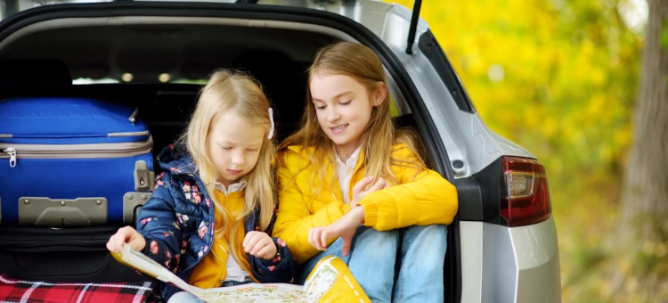 Dziewczynki przeglądają mapę na parkingu podczas postoju