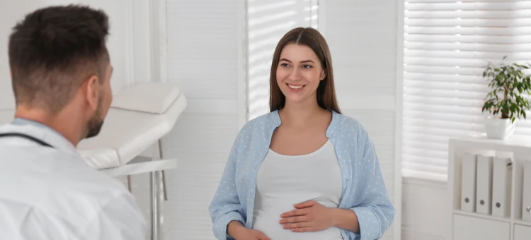 Lekarz rozmawia z kobietą w ciąży w gabinecie lekarskim