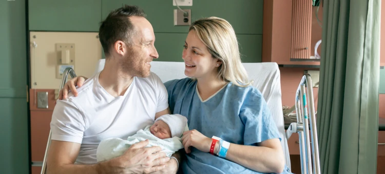 Kobieta i mężczyzna po porodzie na łóżku szpitalnym