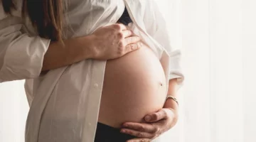 Kobieta w ciąży trzymająca brzuch – objawy i diagnostyka zaśniadu groniastego