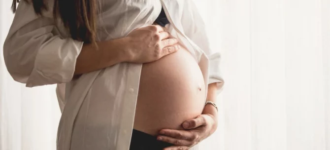 Kobieta w ciąży trzymająca brzuch – objawy i diagnostyka zaśniadu groniastego