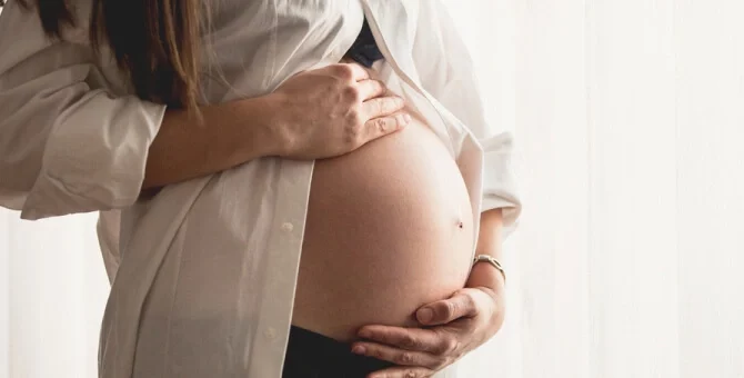 Kobieta w ciąży trzymająca brzuch – objawy i diagnostyka zaśniadu groniastego